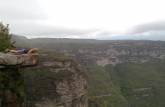 Pendurada no mirante de observação da Cachoeira da Fumaça, próximo à vila do Capão, na Chapada Diamantina - BA